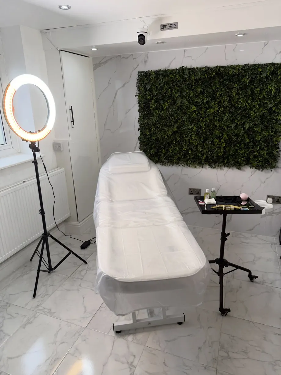 Actual Beauté By Alaïa Aesthetics treatment room with white treatment bed and circular ring light
