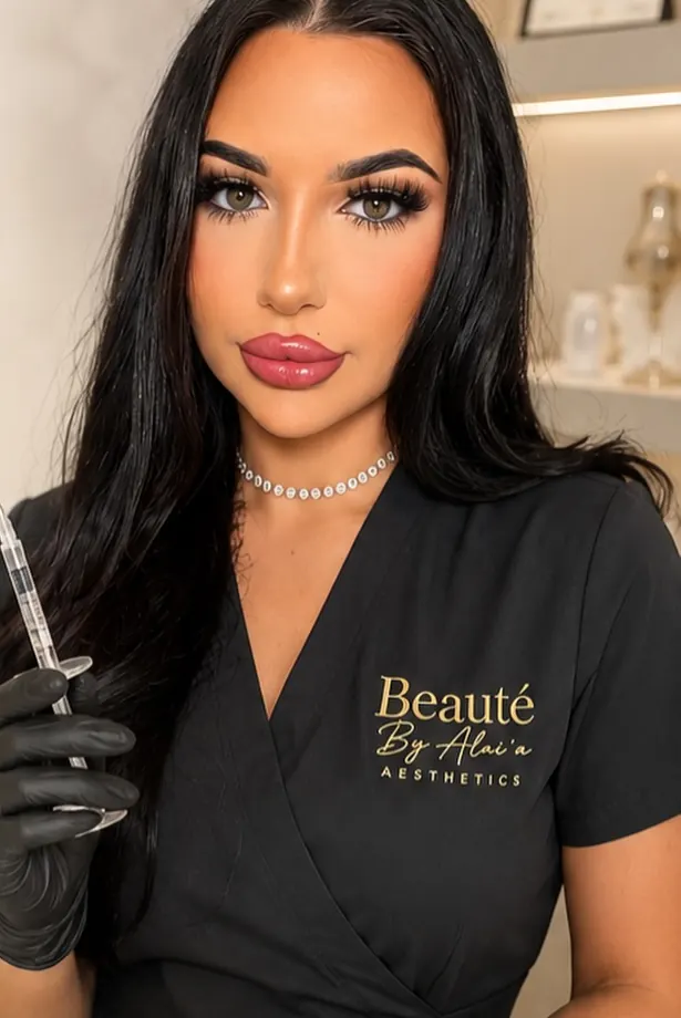 Practitioner wearing black branded aesthetics uniform